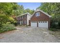 Traditional brick home with a two-car garage and mature trees in a serene, wooded setting at 2607 Buffaloe Rd, Garner, NC 27529