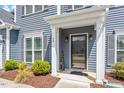 Cozy front porch and door on a two-story home, with landscaped garden beds and shutters at 30 Dowdy Ct, Youngsville, NC 27596