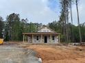 New home under construction with covered porch, surrounded by tall trees, on a partially cleared lot at 329 Green Pines Estates Dr, Kenly, NC 27542