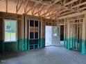 Unfinished room featuring exposed framing, an open doorway and window, ready for customization at 329 Green Pines Estates Dr, Kenly, NC 27542
