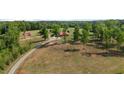 Scenic property view of a home with red roof amid trees, revealing a sprawling lawn at 342 Mcleod Rd, Broadway, NC 27505