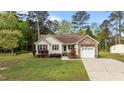 Single-story home featuring charming curb appeal with stone details, a garage, and a well-kept lawn at 35 Vauxhall Ct, Youngsville, NC 27596