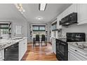 Bright kitchen features white cabinets, granite countertops, stainless steel appliances, and a dining area with large windows at 35 Vauxhall Ct, Youngsville, NC 27596