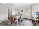 Bright dining room featuring an elegant chandelier, a rustic wood table, and stylish blue and pink upholstered chairs at 3901 Bluffwind Dr, Raleigh, NC 27603