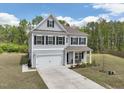 Charming two-story home featuring gray siding, black shutters, a well-manicured lawn, and an attached two-car garage at 3901 Bluffwind Dr, Raleigh, NC 27603