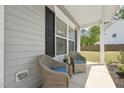 Inviting front porch with two wicker chairs and blue cushions, perfect for relaxing and enjoying the neighborhood view at 3901 Bluffwind Dr, Raleigh, NC 27603