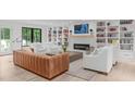 Bright living room with a cozy fireplace, built-in bookshelves, and modern furnishings at 401 Brinkman Ct, Raleigh, NC 27614