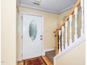 Inviting entryway featuring a decorative front door, hardwood floors and staircase with white painted wood risers at 4125 Palafox Ct, Raleigh, NC 27604