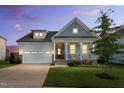 Charming home with a covered front porch, two-car garage, manicured lawn, and beautiful landscaping at twilight at 4333 Benton Mill Dr, Fuquay Varina, NC 27526
