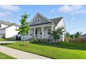 Charming home with a covered front porch, two-car garage, manicured lawn, and beautiful landscaping at 4333 Benton Mill Dr, Fuquay Varina, NC 27526