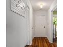 Bright hallway with hardwood floors, fresh paint, coat rack, and neutral colored front door with hardware at 4617 Fawnbrook Cir, Raleigh, NC 27612