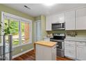 Charming kitchen featuring stainless steel appliances, white cabinetry, and a bright window with scenic view at 4617 Fawnbrook Cir, Raleigh, NC 27612