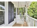 Inviting front porch with a swing, white railing, and views of the surrounding yard at 4711 Buttonbush Dr, Durham, NC 27712