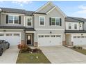 Two-story townhome featuring a two-car garage and neutral gray siding at 484 Autumn Rain St, Cary, NC 27519