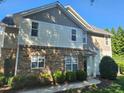 Charming townhouse featuring stone accents and well-maintained landscaping on a sunny day at 5033 Amber Clay Ln, Raleigh, NC 27612