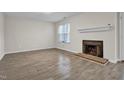 Living room featuring a fireplace with mantel, tile detail, and wood-look floors at 505 Gooseneck Dr # A1, Cary, NC 27513