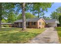 A lovely brick home featuring a car port and a well-maintained lawn at 515 Oakwood Ln, Graham, NC 27253