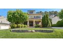 Inviting two-story home featuring a stone retaining wall and lush, green landscaping at 528 Bankhead Dr, Cary, NC 27519