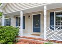 Inviting front porch with classic columns, charming details, and brick steps leading to the entryway at 5420 Royal Troon Dr, Raleigh, NC 27604