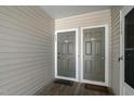 Close up shot of the unit entrance, with 2 gray doors, welcome mats and beige siding at 6011 Winterpointe Ln # 205, Raleigh, NC 27606