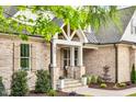Charming porch features stone accents, white columns, and a cozy seating area at 669 Balmoral St, Clayton, NC 27520
