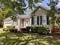 Well-maintained home featuring mature landscaping, an attached garage, and classic architectural details at 6715 St Johns Ct, Raleigh, NC 27616