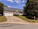 Inviting single-Gathering home featuring a spacious driveway, attached garage, and a well-kept lawn at 6715 St Johns Ct, Raleigh, NC 27616