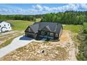 Aerial view of a modern home with a spacious yard and private driveway in a serene, tree-lined neighborhood at 8629 Dukes Lake Rd, Zebulon, NC 27597