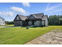 Craftsman style house with black trim, manicured lawns and landscaping around the house at 8629 Dukes Lake Rd, Zebulon, NC 27597