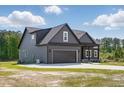 The exterior of this home showcases modern architecture and design, with a garage and well-maintained lawn at 8629 Dukes Lake Rd, Zebulon, NC 27597