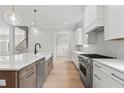 Kitchen boasts a central island, stainless appliances, and white cabinetry for a modern and functional design at 9305 Field Maple Ct, Raleigh, NC 27613
