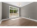 Sunlit bedroom features hardwood floors and a large window overlooking the front yard at 9309 Field Maple Ct, Raleigh, NC 27613