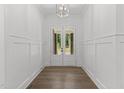 Elegant foyer featuring hardwood floors and white wainscoting, illuminated by modern lighting at 9309 Field Maple Ct, Raleigh, NC 27613