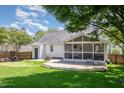 Spacious backyard with a screened-in porch, deck, and lush green lawn at 9404 Dawnshire Rd, Raleigh, NC 27615