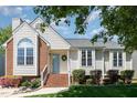 A bright house with light siding, a brick chimney, and a wreath on the front door at 9404 Dawnshire Rd, Raleigh, NC 27615