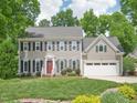 Beautiful two-story home with a landscaped front yard, gray siding, and a two-car garage at 104 Montauk Point Pl, Cary, NC 27513