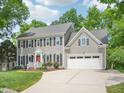 Charming two-story house featuring gray siding, black shutters, and an attached two-car garage at 104 Montauk Point Pl, Cary, NC 27513