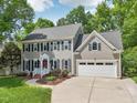 Attractive two-story home boasting gray siding, black shutters, and an attached two-car garage at 104 Montauk Point Pl, Cary, NC 27513