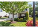 Well-maintained home with lush landscaping, a two-car garage, and a welcoming front lawn at 1230 Sunday Silence Dr, Knightdale, NC 27545