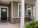 Inviting front porch with brick accents, classic columns, and cozy seating area at 1242 Underbrush Dr, Durham, NC 27703