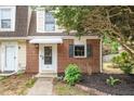 Close-up of the brick exterior and front door with an awning and landscaped garden at 13 Patriot Cir, Durham, NC 27704