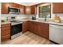 Modern kitchen featuring wood cabinets, granite countertops, and stainless steel appliances at 13 Patriot Cir, Durham, NC 27704
