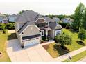 Stunning two-story home with a stone and tan facade, a two-car garage and manicured lawn at 1429 Wragby Ln, Apex, NC 27502