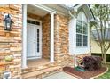 Inviting front entrance with stone detailing, decorative columns, and a stylish black lantern at 146 Rockport Ridge Way, Cary, NC 27519