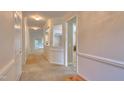 Bright hallway featuring neutral walls, carpet flooring, and open archways leading to other rooms at 146 Rockport Ridge Way, Cary, NC 27519