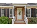 A welcoming front porch with white railings and a decorative wreath on the front door at 160 Fox Run Rd, Youngsville, NC 27596