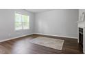 Neutral bedroom with wood floors, fireplace, and window with blinds; carpeted floor with rug detail at 162 W Lumber Ct, Clayton, NC 27520