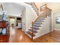 Elegant foyer with hardwood floors and staircase with black iron spindles at 1710 Eddy Ct, Franklinton, NC 27525