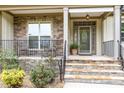 Inviting front porch with stone accents, rocking chairs, and a decorative front door at 1710 Eddy Ct, Franklinton, NC 27525