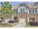 Charming townhouse with stone accents, well-maintained landscaping, and attached one car garage at 19 Sangre De Cristo Dr, Durham, NC 27705